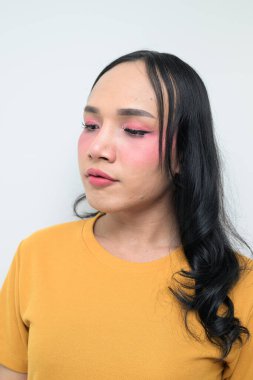 Makyajlı ve uzun saçlı Taylandlı genç bir transseksüelin stüdyo portresi. Cinsiyet ifadesi kavramı, LGBTQ gururu ve özgün güzellik ve çeşitliliği gösteren kapsayıcılık.