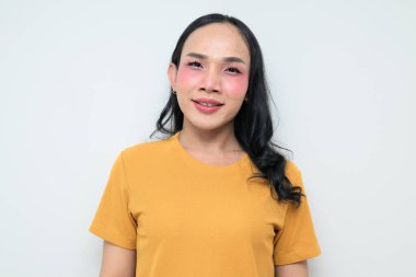 Makyajlı ve uzun saçlı Taylandlı genç bir transseksüelin stüdyo portresi. Cinsiyet ifadesi kavramı, LGBTQ gururu ve özgün güzellik ve çeşitliliği gösteren kapsayıcılık.