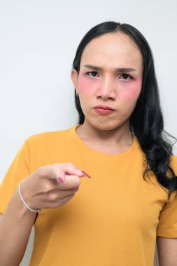 Makyajlı ve uzun saçlı Taylandlı genç bir transseksüelin stüdyo portresi. Cinsiyet ifadesi kavramı, LGBTQ gururu ve özgün güzellik ve çeşitliliği gösteren kapsayıcılık.