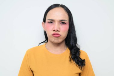 Makyajlı ve uzun saçlı Taylandlı genç bir transseksüelin stüdyo portresi. Cinsiyet ifadesi kavramı, LGBTQ gururu ve özgün güzellik ve çeşitliliği gösteren kapsayıcılık.