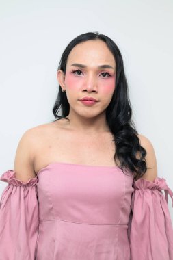 Makyajlı ve uzun saçlı Taylandlı genç bir transseksüelin stüdyo portresi. Cinsiyet ifadesi kavramı, LGBTQ gururu ve özgün güzellik ve çeşitliliği gösteren kapsayıcılık.