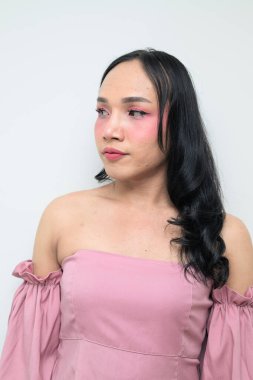 Makyajlı ve uzun saçlı Taylandlı genç bir transseksüelin stüdyo portresi. Cinsiyet ifadesi kavramı, LGBTQ gururu ve özgün güzellik ve çeşitliliği gösteren kapsayıcılık.