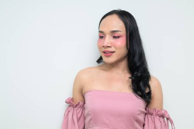 Makyajlı ve uzun saçlı Taylandlı genç bir transseksüelin stüdyo portresi. Cinsiyet ifadesi kavramı, LGBTQ gururu ve özgün güzellik ve çeşitliliği gösteren kapsayıcılık.