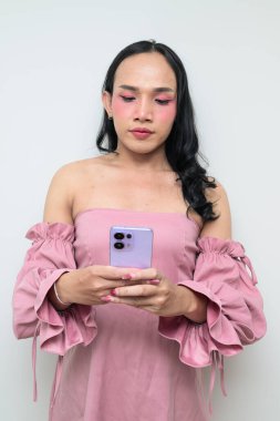 Makyajlı ve uzun saçlı Taylandlı genç bir transseksüelin stüdyo portresi. Cinsiyet ifadesi kavramı, LGBTQ gururu ve özgün güzellik ve çeşitliliği gösteren kapsayıcılık.