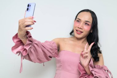 Makyajlı ve uzun saçlı Taylandlı genç bir transseksüelin stüdyo portresi. Cinsiyet ifadesi kavramı, LGBTQ gururu ve özgün güzellik ve çeşitliliği gösteren kapsayıcılık.