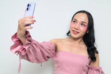 Makyajlı ve uzun saçlı Taylandlı genç bir transseksüelin stüdyo portresi. Cinsiyet ifadesi kavramı, LGBTQ gururu ve özgün güzellik ve çeşitliliği gösteren kapsayıcılık.