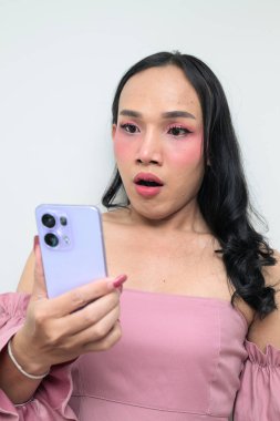 Makyajlı ve uzun saçlı Taylandlı genç bir transseksüelin stüdyo portresi. Cinsiyet ifadesi kavramı, LGBTQ gururu ve özgün güzellik ve çeşitliliği gösteren kapsayıcılık.