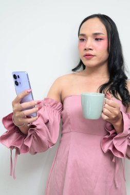 Makyajlı ve uzun saçlı Taylandlı genç bir transseksüelin stüdyo portresi. Cinsiyet ifadesi kavramı, LGBTQ gururu ve özgün güzellik ve çeşitliliği gösteren kapsayıcılık.