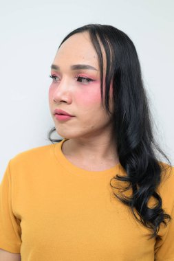 Makyajlı ve uzun saçlı Taylandlı genç bir transseksüelin stüdyo portresi. Cinsiyet ifadesi kavramı, LGBTQ gururu ve özgün güzellik ve çeşitliliği gösteren kapsayıcılık.