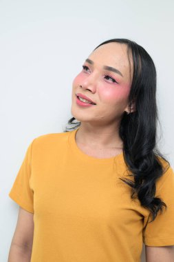 Makyajlı ve uzun saçlı Taylandlı genç bir transseksüelin stüdyo portresi. Cinsiyet ifadesi kavramı, LGBTQ gururu ve özgün güzellik ve çeşitliliği gösteren kapsayıcılık.