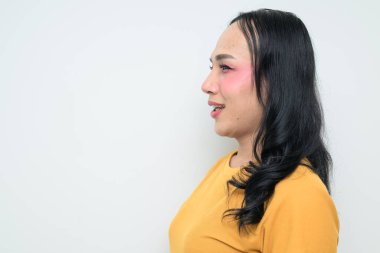 Makyajlı ve uzun saçlı Taylandlı genç bir transseksüelin stüdyo portresi. Cinsiyet ifadesi kavramı, LGBTQ gururu ve özgün güzellik ve çeşitliliği gösteren kapsayıcılık.