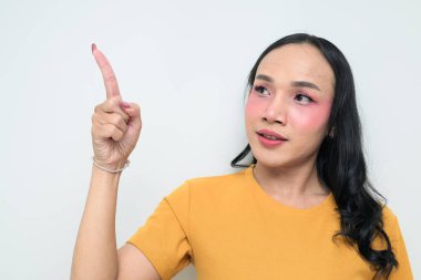 Makyajlı ve uzun saçlı Taylandlı genç bir transseksüelin stüdyo portresi. Cinsiyet ifadesi kavramı, LGBTQ gururu ve özgün güzellik ve çeşitliliği gösteren kapsayıcılık.