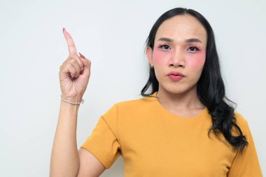 Makyajlı ve uzun saçlı Taylandlı genç bir transseksüelin stüdyo portresi. Cinsiyet ifadesi kavramı, LGBTQ gururu ve özgün güzellik ve çeşitliliği gösteren kapsayıcılık.