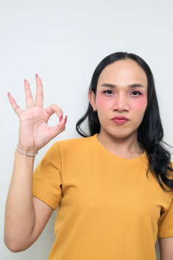 Makyajlı ve uzun saçlı Taylandlı genç bir transseksüelin stüdyo portresi. Cinsiyet ifadesi kavramı, LGBTQ gururu ve özgün güzellik ve çeşitliliği gösteren kapsayıcılık.