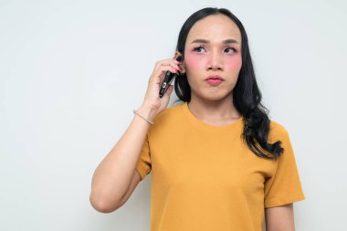 Telefon kullanarak uzun saçlı, makyajlı Taylandlı genç bir transseksüelin stüdyo portresi. Cinsiyet ifadesi kavramı, LGBTQ gururu ve özgün güzellik ve çeşitliliği gösteren kapsayıcılık.
