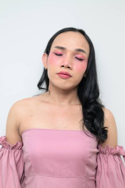Makyajlı ve uzun saçlı Taylandlı genç bir transseksüelin stüdyo portresi. Cinsiyet ifadesi kavramı, LGBTQ gururu ve özgün güzellik ve çeşitliliği gösteren kapsayıcılık.