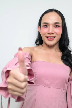 Makyajlı ve uzun saçlı Taylandlı genç bir transseksüelin stüdyo portresi. Cinsiyet ifadesi kavramı, LGBTQ gururu ve özgün güzellik ve çeşitliliği gösteren kapsayıcılık.