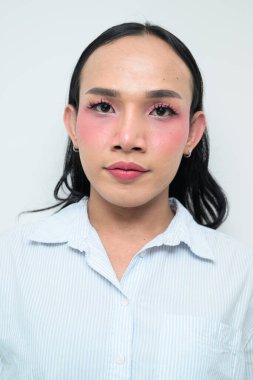 Makyajlı ve uzun saçlı Taylandlı genç bir transseksüelin stüdyo portresi. Cinsiyet ifadesi kavramı, LGBTQ gururu ve özgün güzellik ve çeşitliliği gösteren kapsayıcılık.