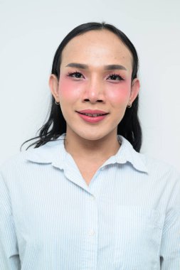 Makyajlı ve uzun saçlı Taylandlı genç bir transseksüelin stüdyo portresi. Cinsiyet ifadesi kavramı, LGBTQ gururu ve özgün güzellik ve çeşitliliği gösteren kapsayıcılık.