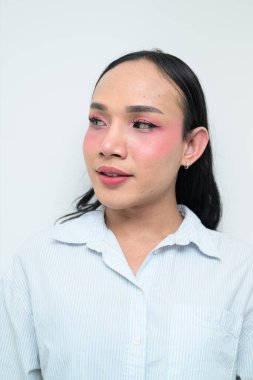 Makyajlı ve uzun saçlı Taylandlı genç bir transseksüelin stüdyo portresi. Cinsiyet ifadesi kavramı, LGBTQ gururu ve özgün güzellik ve çeşitliliği gösteren kapsayıcılık.