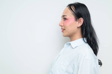 Makyajlı ve uzun saçlı Taylandlı genç bir transseksüelin stüdyo portresi. Cinsiyet ifadesi kavramı, LGBTQ gururu ve özgün güzellik ve çeşitliliği gösteren kapsayıcılık.