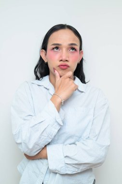 Makyajlı ve uzun saçlı Taylandlı genç bir transseksüelin stüdyo portresi. Cinsiyet ifadesi kavramı, LGBTQ gururu ve özgün güzellik ve çeşitliliği gösteren kapsayıcılık.