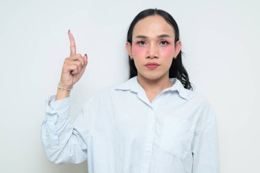 Makyajlı ve uzun saçlı Taylandlı genç bir transseksüelin stüdyo portresi. Cinsiyet ifadesi kavramı, LGBTQ gururu ve özgün güzellik ve çeşitliliği gösteren kapsayıcılık.