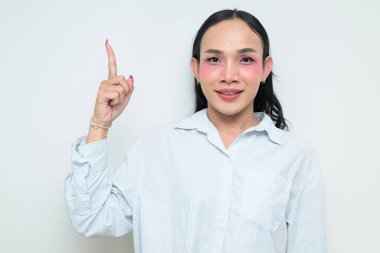 Makyajlı ve uzun saçlı Taylandlı genç bir transseksüelin stüdyo portresi. Cinsiyet ifadesi kavramı, LGBTQ gururu ve özgün güzellik ve çeşitliliği gösteren kapsayıcılık.