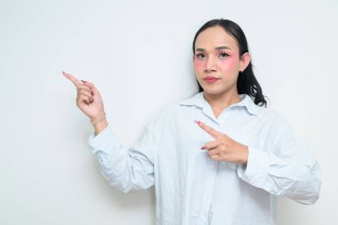 Makyajlı ve uzun saçlı Taylandlı genç bir transseksüelin stüdyo portresi. Cinsiyet ifadesi kavramı, LGBTQ gururu ve özgün güzellik ve çeşitliliği gösteren kapsayıcılık.