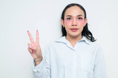 Makyajlı ve uzun saçlı Taylandlı genç bir transseksüelin stüdyo portresi. Cinsiyet ifadesi kavramı, LGBTQ gururu ve özgün güzellik ve çeşitliliği gösteren kapsayıcılık.