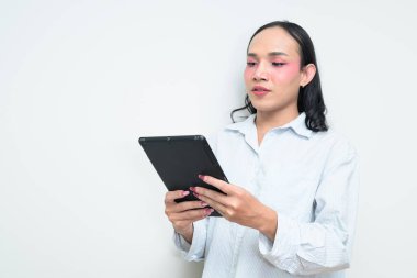 Makyajlı ve uzun saçlı Taylandlı genç bir transseksüelin stüdyo portresi. Cinsiyet ifadesi kavramı, LGBTQ gururu ve özgün güzellik ve çeşitliliği gösteren kapsayıcılık.