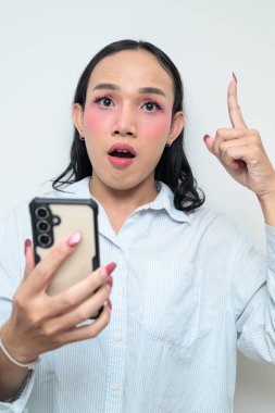 Makyajlı ve uzun saçlı Taylandlı genç bir transseksüelin stüdyo portresi. Cinsiyet ifadesi kavramı, LGBTQ gururu ve özgün güzellik ve çeşitliliği gösteren kapsayıcılık.