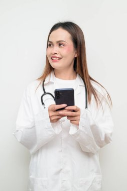 Beyaz önlük giyen ve steteskop kullanan Asyalı bir sağlık uzmanının stüdyo portresi. Tıbbi, hastane, klinik ve sağlık konularına uygun kavram.