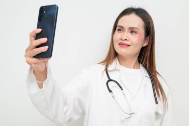 Beyaz önlük giyen ve steteskop kullanan Asyalı bir sağlık uzmanının stüdyo portresi. Tıbbi, hastane, klinik ve sağlık konularına uygun kavram.