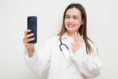 Beyaz önlük giyen ve steteskop kullanan Asyalı bir sağlık uzmanının stüdyo portresi. Tıbbi, hastane, klinik ve sağlık konularına uygun kavram.