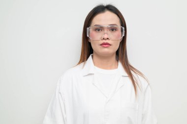 Beyaz önlük ve koruyucu gözlük takan Asyalı bir bilim adamının stüdyo portresi. Laboratuvar, araştırma, bilim, tıp ve klinik temalar için ciddi ve profesyonel görünüm uygun.
