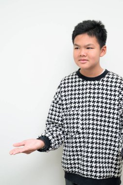 Beyaz arka planda duran Asyalı bir gencin stüdyo portresi. Gençlik, eğitim, aile ve yaşam tarzı temaları için basit görünüm.