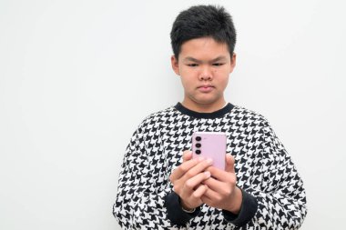 Telefon kullanarak beyaz bir zemine dayanan Asyalı bir gencin stüdyo portresi. Gençlik, eğitim, aile ve yaşam tarzı temaları için basit görünüm.