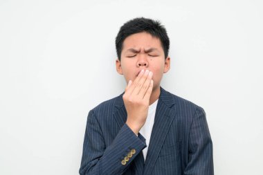 Beyaz bir arka plana karşı resmi takım elbise giyen Asyalı bir gencin stüdyo portresi. İş, eğitim, liderlik, kariyer ve gelecekteki başarı temaları için elverişli.