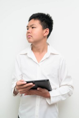 Asyalı bir gencin stüdyo portresi beyaz arka planda düğmeli gömlekle dikiliyor. Gençlik, eğitim, aile ve yaşam tarzı temaları için basit görünüm.