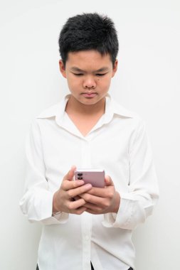 Asyalı bir gencin stüdyo portresi beyaz arka planda düğmeli gömlekle dikiliyor. Gençlik, eğitim, aile ve yaşam tarzı temaları için basit görünüm.