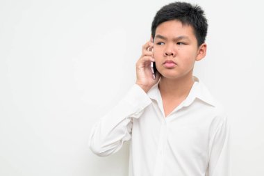 Asyalı bir gencin stüdyo portresi beyaz arka planda düğmeli gömlekle dikiliyor. Gençlik, eğitim, aile ve yaşam tarzı temaları için basit görünüm.