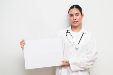 Taylandlı genç bir kadın doktorun portresi. Sağlık hizmetlerinin tanıtımı, klinik markalaşması ya da profesyonel reklamcılık için elinde boş bir tıbbi levha tutuyor..