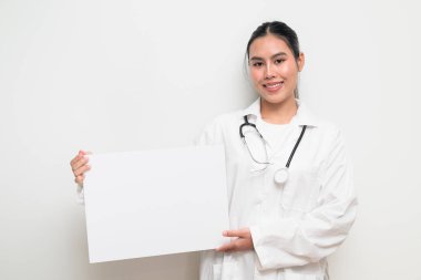 Taylandlı genç bir kadın doktorun portresi. Sağlık hizmetlerinin tanıtımı, klinik markalaşması ya da profesyonel reklamcılık için elinde boş bir tıbbi levha tutuyor..