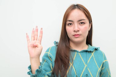 Beyaz arka planda genç bir Asyalı kadının stüdyo portresi dört numarayı parmaklarıyla gösteriyor.