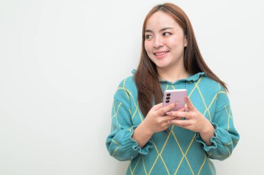 Genç Asyalı bir kadının cep telefonuyla beyaz arkaplan üzerindeki stüdyo portresi