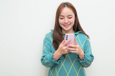 Genç Asyalı bir kadının cep telefonuyla beyaz arkaplan üzerindeki stüdyo portresi