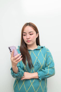 Genç Asyalı bir kadının cep telefonuyla beyaz arkaplan üzerindeki stüdyo portresi