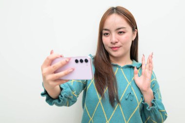 Genç Asyalı bir kadının cep telefonuyla beyaz arkaplan üzerindeki stüdyo portresi