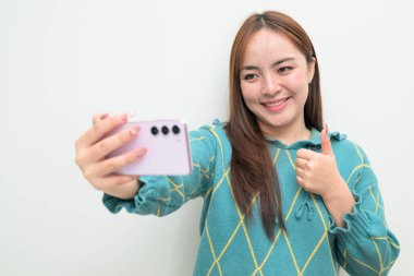 Genç Asyalı bir kadının cep telefonuyla beyaz arkaplan üzerindeki stüdyo portresi